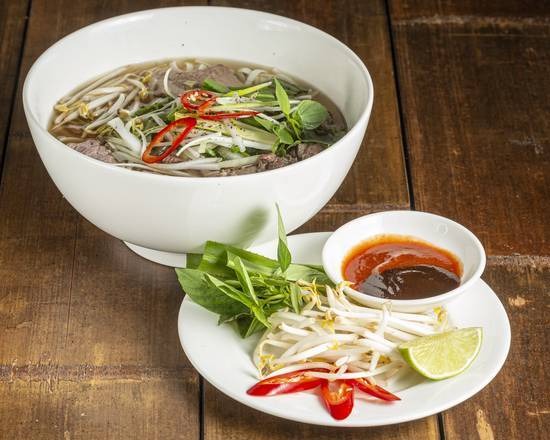 Traditional Phở Bò beef noodle soup with fresh herbs